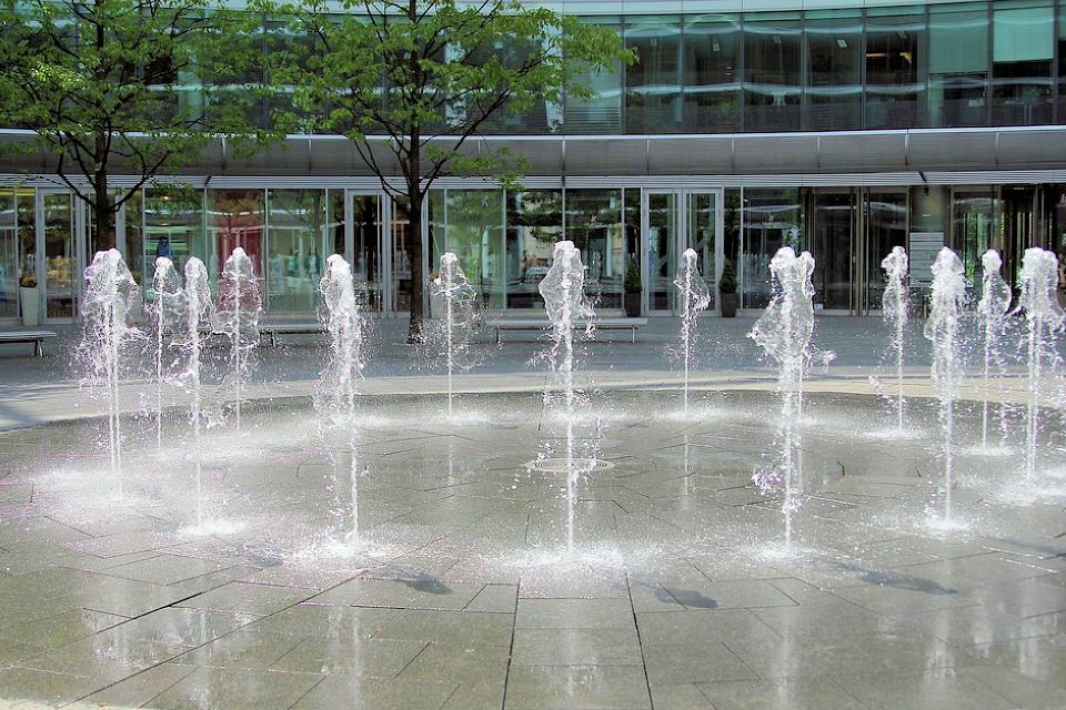 children playing in dry deck fountain at public park