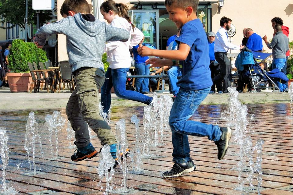 kids playing safely in water jets fountain