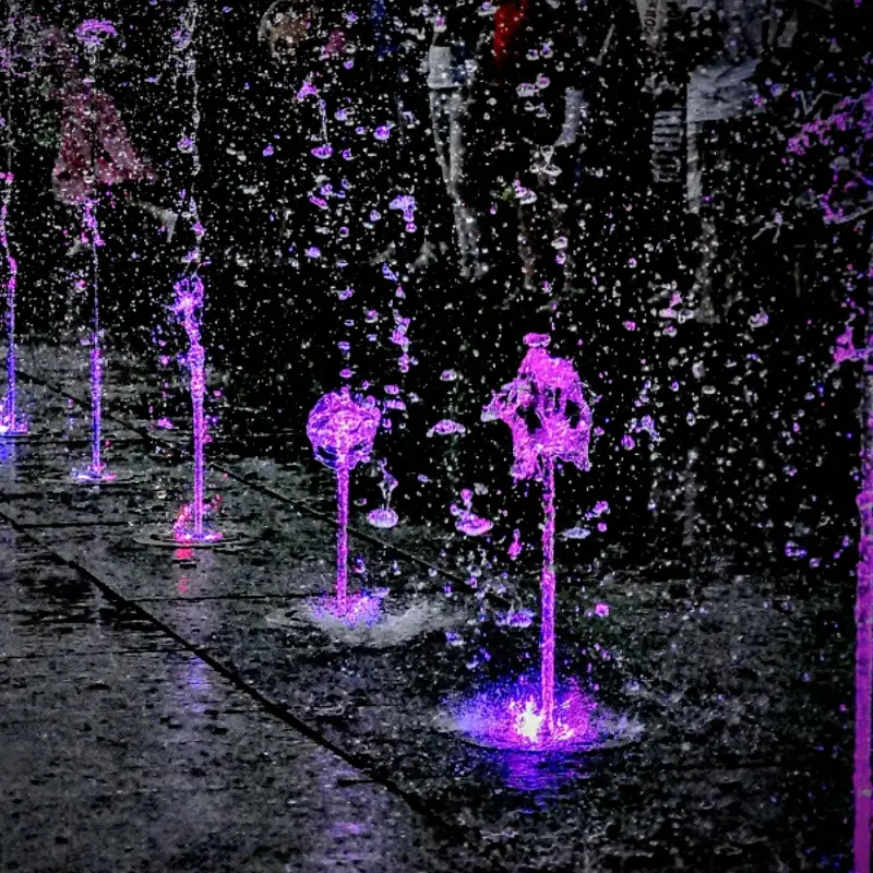 Interactive dry deck fountain with ground-level water jets for children play area